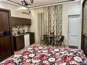 a bedroom with a large bed with a floral blanket at cosy house in K'obulet'i +3 photos