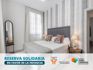 格拉纳达Apartamentos Puerta Elvira Suites 3000的一间带床和窗户的白色卧室