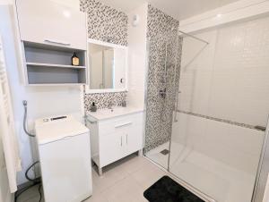 a white bathroom with a shower and a sink at T3 neuf Baignots proche Thermes, centre, parking in Dax