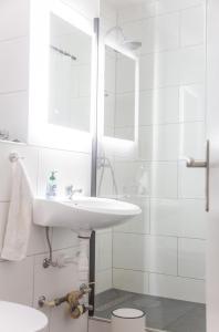 a white bathroom with a sink and a mirror at Wohnung Smart-TV, Küche, Balkon in Emden