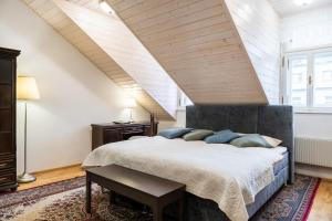 a bedroom with a large bed with blue pillows at Spa Jewel - Stylish Flat in the Center! with Sauna in Karlovy Vary