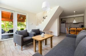 een woonkamer met een bank, stoelen en een tafel bij Leśna7 in Sztutowo