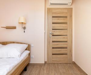 een slaapkamer met een bed en een houten deur bij Leśna7 in Sztutowo