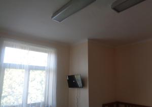 a room with a window and a television on the wall at Hotel U Lázní - ubytování pro nenáročné in Ostrožská Nová Ves