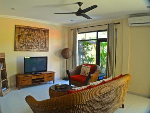 a living room with two chairs and a television at Villa Taluh in Sanur