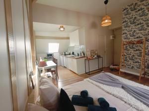 a living room with a kitchen and a bed in it at Les Suites Marcel Proust in Illiers