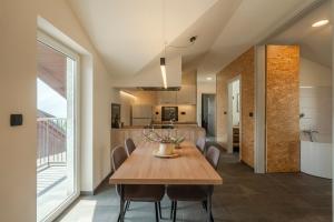 Un comedor y una cocina con mesa y sillas de madera. en Holiday Home Lukc with free parking, en Kobarid