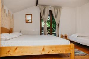 a bedroom with two beds and a large window at Casa BOBO in Baia de Fier