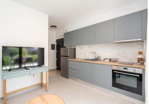 a kitchen with gray and white cabinets and a table at Diamond D2 Iraklitsa in Iraklitsa