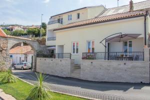 a house with a balcony with an umbrella at Dida moj in Senj