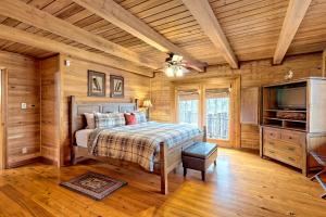 - une chambre avec un lit, une télévision et des murs en bois dans l'établissement Secluded Mountain Cabin close to Helen, Georgia, Perfect for a Family Getaway, à Sautee Nacoochee