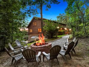 un groupe de chaises autour d'un foyer extérieur devant une cabine dans l'établissement Secluded Mountain Cabin close to Helen, Georgia, Perfect for a Family Getaway, à Sautee Nacoochee
