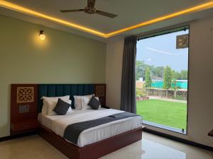 Un dormitorio con una cama y una ventana grande. en Hotel Basant palace, en Pushkar