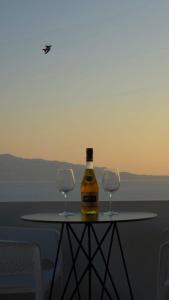 a bottle of wine sitting on a table with two glasses at Hotel Eleana & Apartments in Sarandë