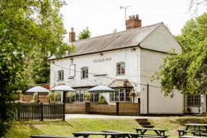 a white building with umbrellas in front of it at The Bell Inn, Ladbroke in Ladbroke