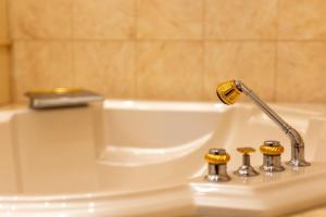 a white bath tub with a faucet on a sink at Exclusive Apartment in Vienna +3 photos