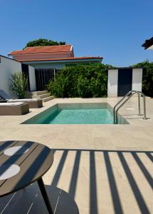 a swimming pool in front of a house at Courtyard Villa, Aleksandrovo in Aleksandrovo