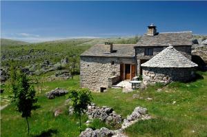 an old stone house in a grassy field at Le petit gite du veygalier in Fraissinet-de-Fourques