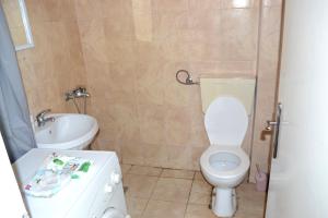 a bathroom with a white toilet and a sink at Luka Apartman in Bitola