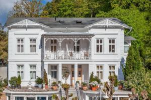 ein großes weißes Haus mit verziertem Tor in der Unterkunft Villa Granitz Wind & Wolke in Ostseebad Sellin