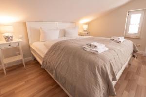 ein Schlafzimmer mit einem Bett mit zwei Handtüchern darauf in der Unterkunft Villa Granitz Wind & Wolke in Ostseebad Sellin
