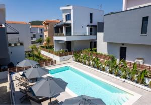a swimming pool with umbrellas in front of a building at Diamond D2 Iraklitsa in Iraklitsa