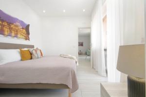 a white bedroom with a bed and a hallway at Attico Soleggiato con Terrazza a Ostia in Lido di Ostia +24 photos