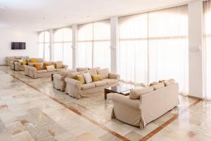 a large room with couches and tables and windows at RVHotels Golf Costa Brava in Santa Cristina d'Aro