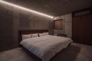 a bedroom with a large white bed in a room at villa irifi 夕陽を望むヴィラ in Miyako Island