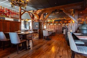 a restaurant with wooden floors and tables and chairs at Hotel Hartlief in Buinen