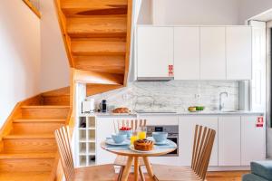 eine Küche mit weißen Schränken und einem Tisch mit Essen drauf in der Unterkunft Framed Corner by Portugal Active in Porto