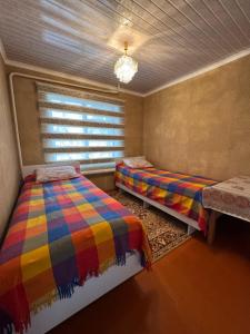 a bedroom with two beds and a window at Guest House Baiel in Bokonbayevo