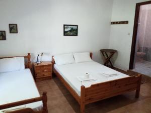 a bedroom with two beds and a table and a mirror at Athanasios Stafylas in Samothráki