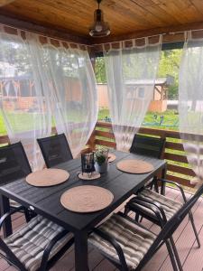 a black table with four chairs on a porch at Bungalow Camp Velenje in Velenje