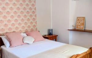 a bedroom with a bed with pink and white pillows at Maroudas Traditional Guest House in Vathi