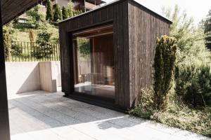 a wooden house with a large glass door at Max Relax SUMMERCARD INCLUDED Ski in-ski out in Zell am See