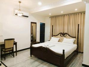 a bedroom with a bed and a desk and a chair at Hotel Jheel Mahal near City Palace in Udaipur