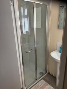 eine Glasdusche im Bad mit Waschbecken in der Unterkunft Glasgow house in Londonderry County Borough