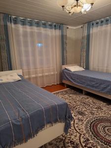 une chambre avec deux lits et un lustre dans l'établissement Guest House Baiel, à Bokonbayevo