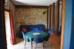 a room with a table and chairs and a couch at Gîte dans la campagne Bretonne - Le jardin de Devant in Villamée