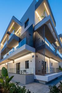 a large white building with balconies at night at Unicos City Suites in Kos Town