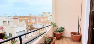 einen Balkon mit Topfpflanzen und Stadtblick in der Unterkunft Bustamante in Roquetas de Mar