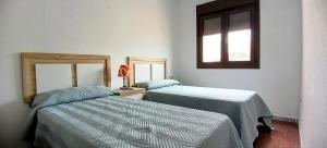 ein Schlafzimmer mit zwei Betten und einem Fenster in der Unterkunft Bustamante in Roquetas de Mar