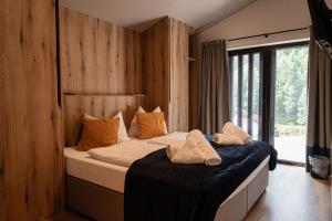 a bedroom with two beds and a large window at Max Relax SUMMERCARD INCLUDED Ski in-ski out in Zell am See