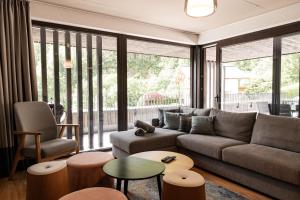 a living room with a couch and a large window at Max Relax SUMMERCARD INCLUDED Ski in-ski out in Zell am See +68 photos