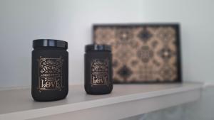 Dos botellas negras en un estante con una imagen. en Galazio suites 2, en Salamina