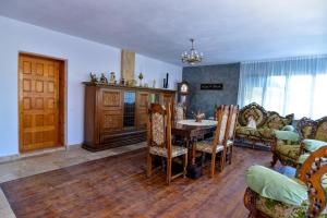 a living room with a table and chairs and a couch at Agropensiune Lupu in Ursăţei