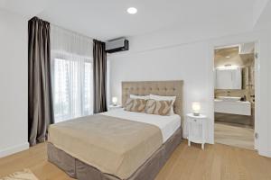En eller flere senge i et værelse på Victoriei Luxury Apartments