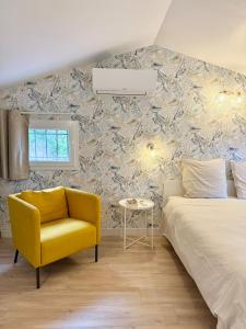 a bedroom with a bed and a yellow chair at CASA ANPÀ Maison Vue Mer in Lecci