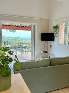 a living room with a green couch and a table and chairs at CASA ANPÀ Maison Vue Mer in Lecci +67 photos